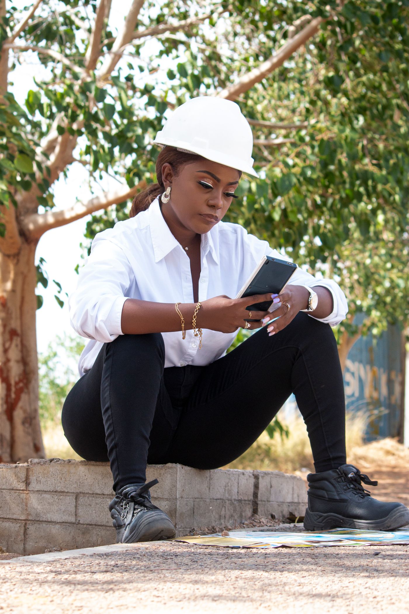 Ingénieure africaine utilisant un smartphone pour le suivi digital d'un chantier